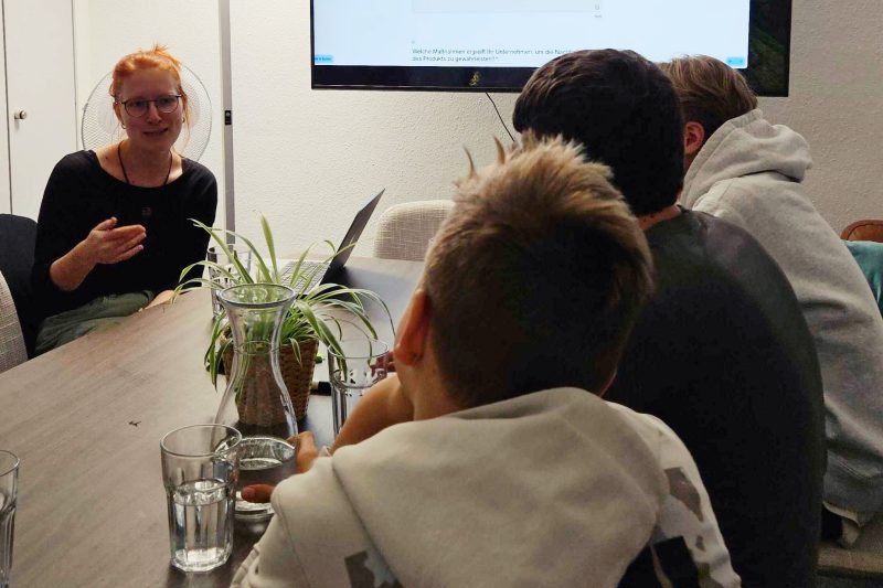 Schuelergruppe-Umweltprofis-Evergreen-01-quer Schülergruppe der Umweltprofis von morgen im Evergreen-Büro am Tisch mit CSR-Managerin Hanna Mathias