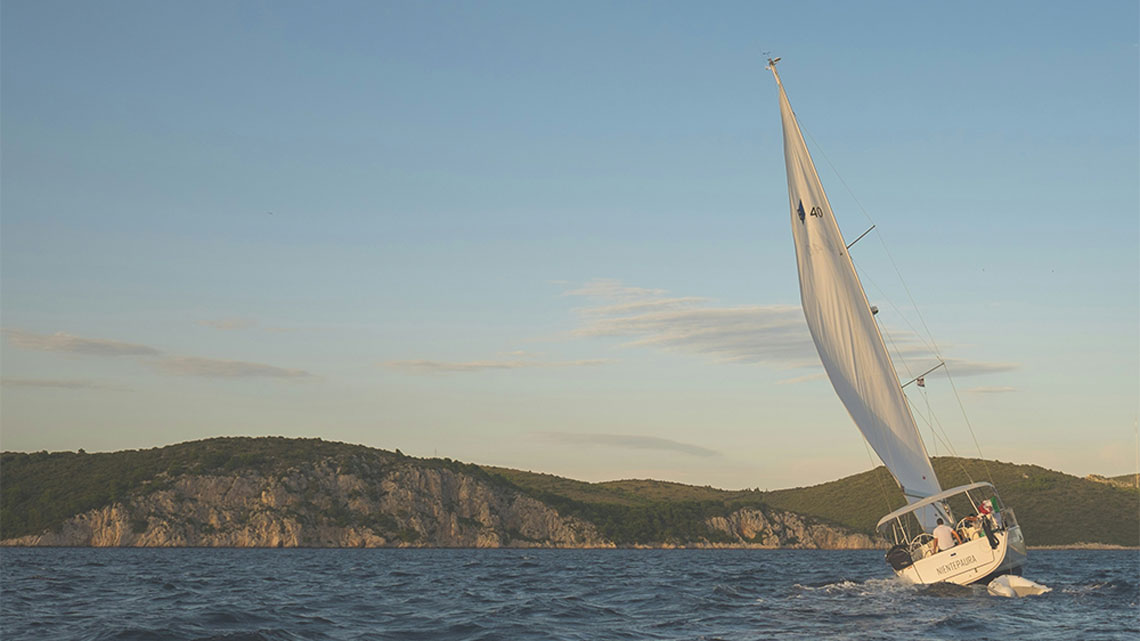 Schief liegendes Segelboot auf offener See mit Wind